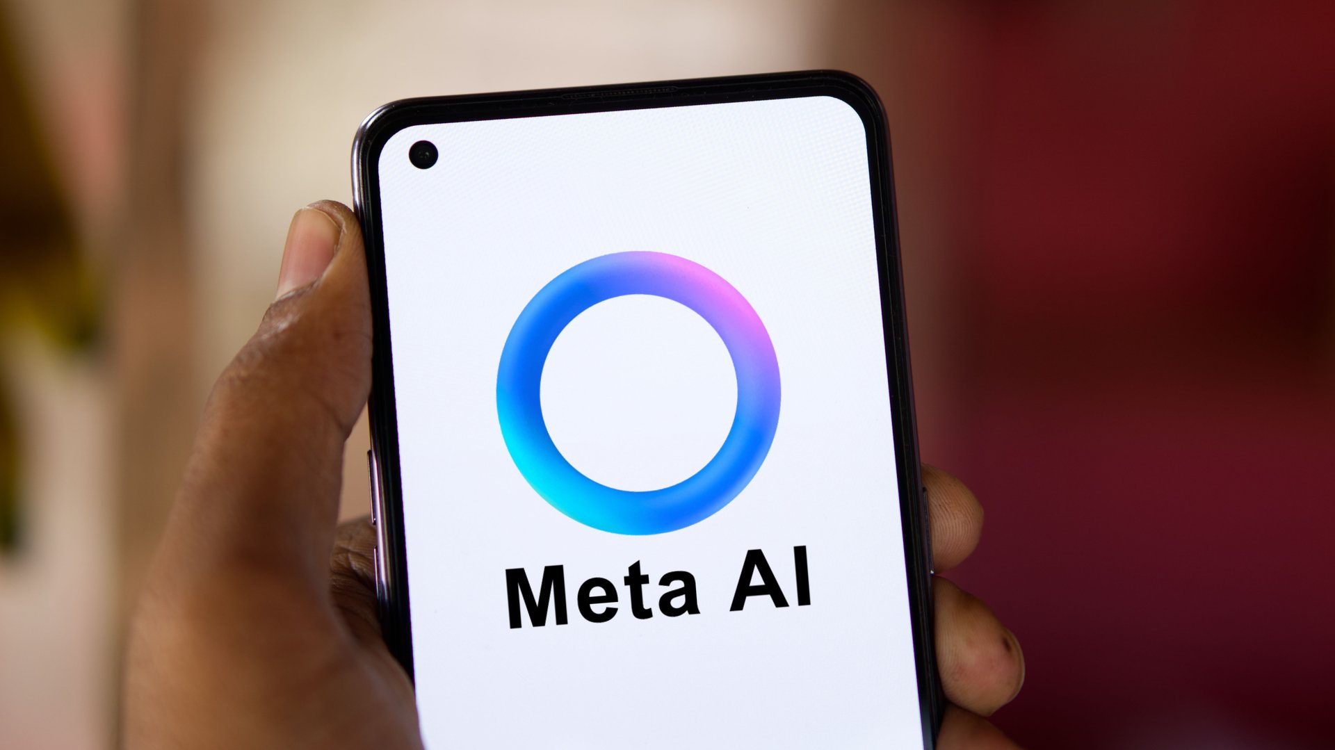 Hình ảnh bàn tay cầm điện thoại hiển thị logo Meta AI hình vòng tròn gradient xanh dương và chữ "Meta AI" trên nền mờ đỏ hồng. Tin chính ngày 29/05/2026: Meta ra mắt gói Meta AI trả phí toàn cầu từ 7,99 đến 19,99 USD/tháng.