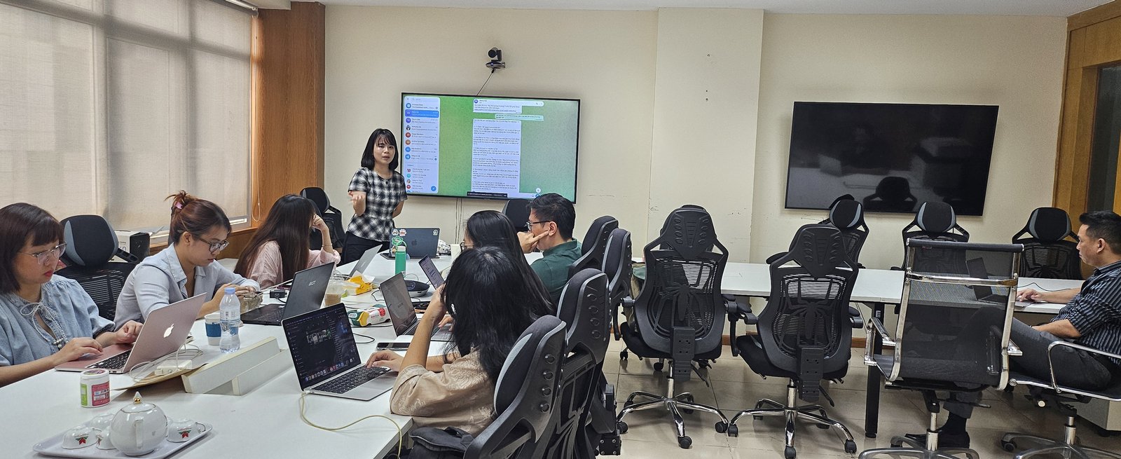 Giảng viên ZTO Labs trình bày trước đội ngũ Znews, màn hình hiển thị demo trợ lý AI, các học viên theo dõi và thực hành trên laptop.